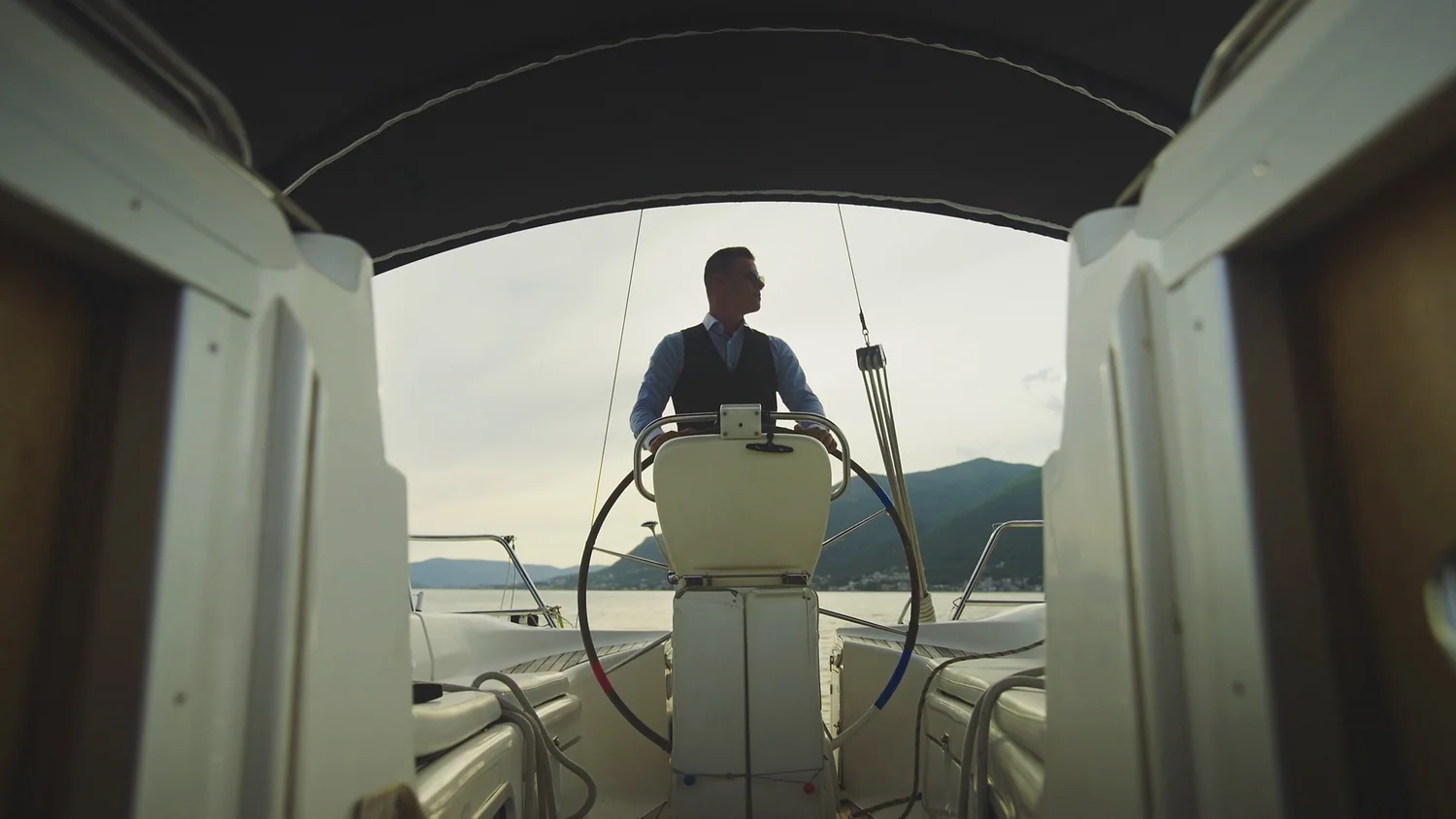 A skipper at the wheel of a sailing yacht
