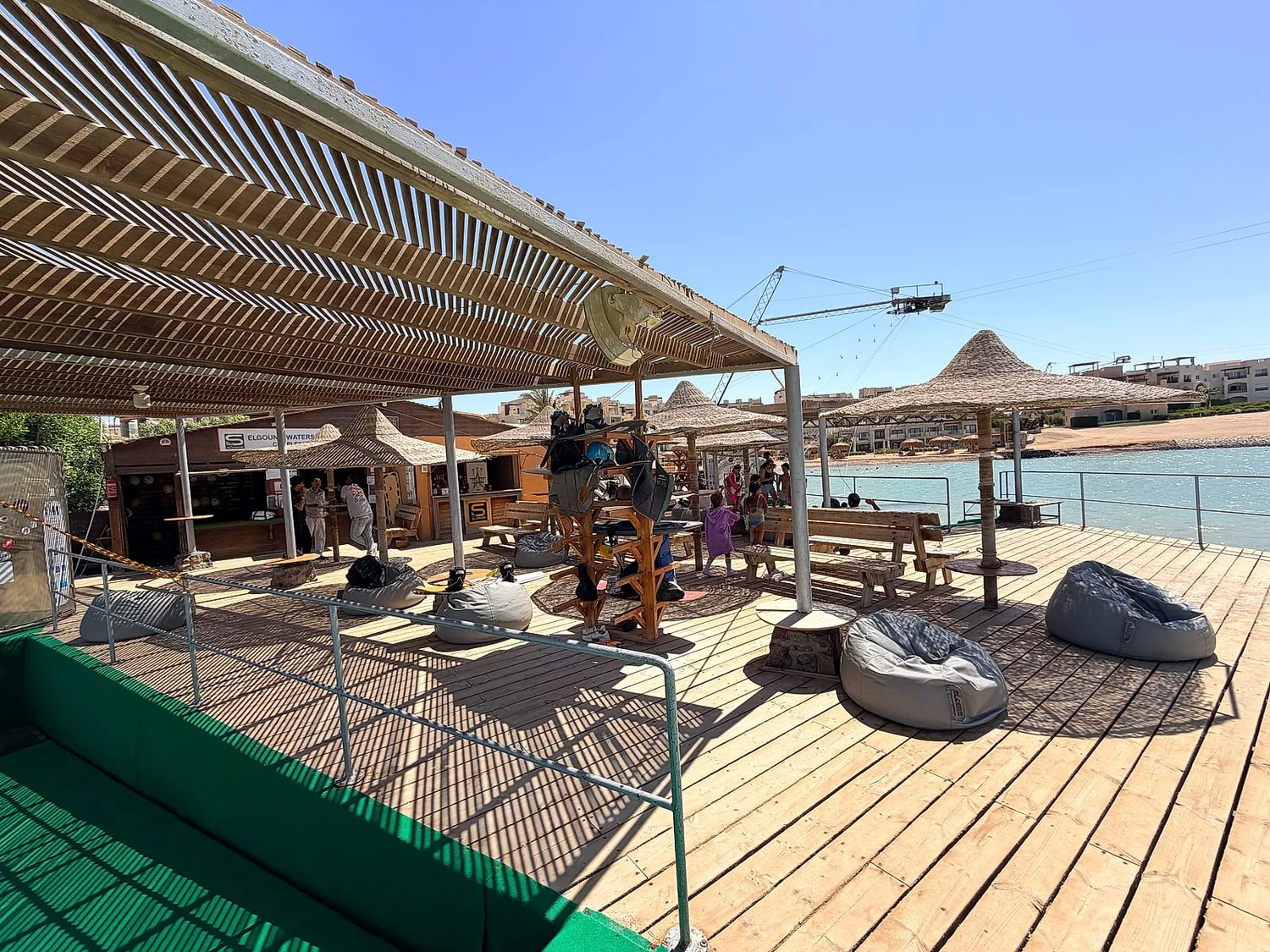 The wooden deck at Sliders with bean bags, benches and the bar under a pergola
