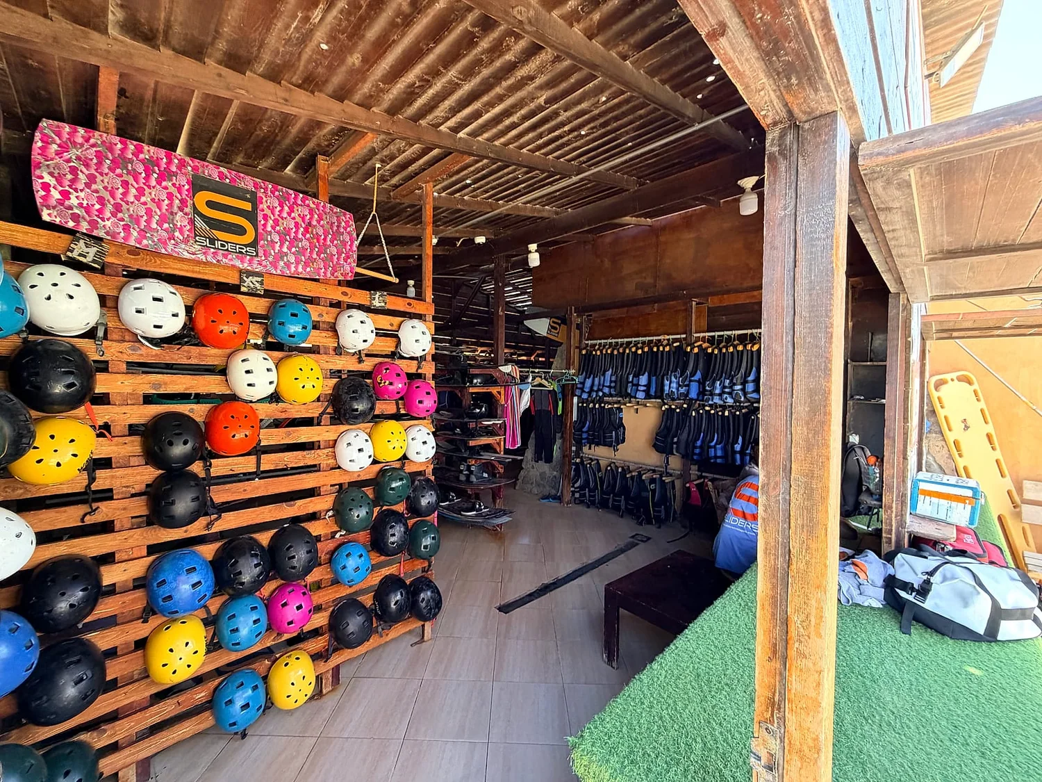 Helmets, vests and boards racked in the gear shack at Sliders Cable Park