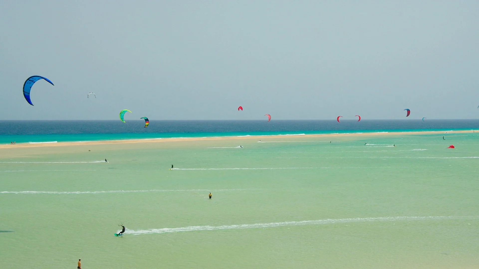 Kitesurfers riding a shallow turquoise lagoon on the Red Sea coast