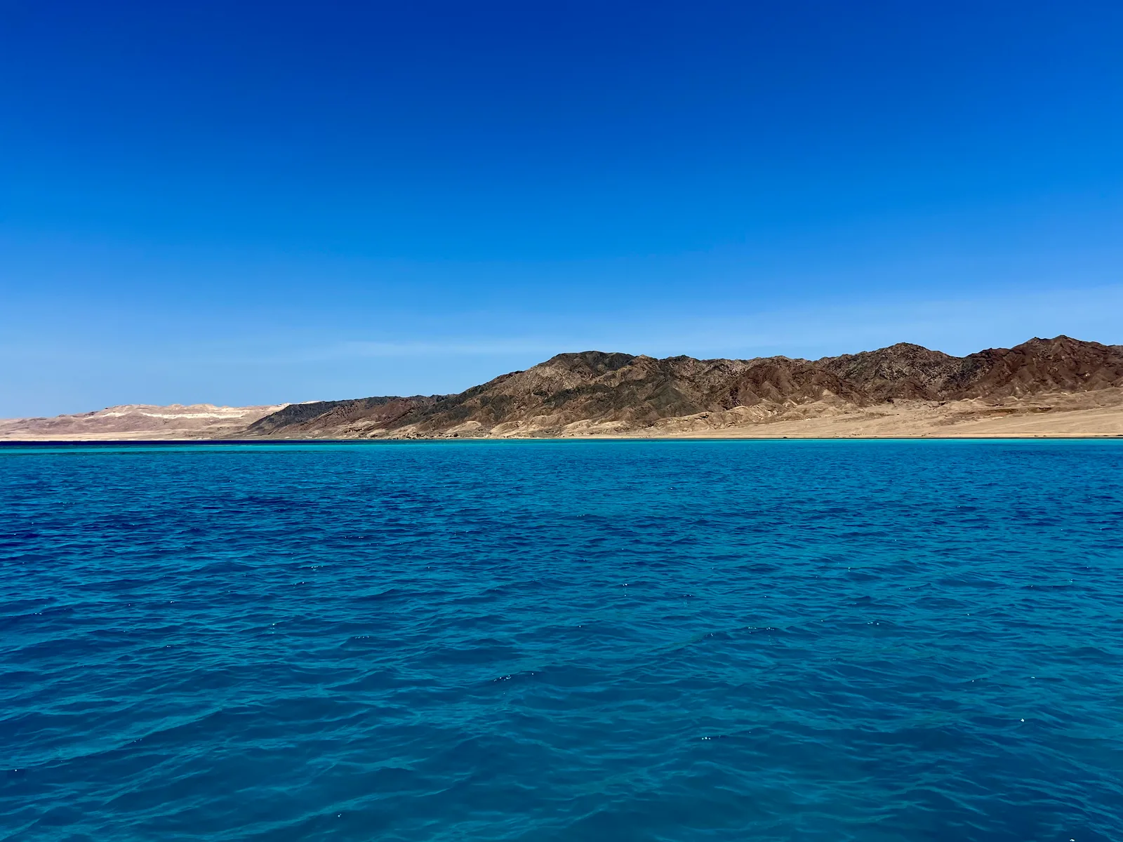 The long shoreline of Shedwan Island under open sky