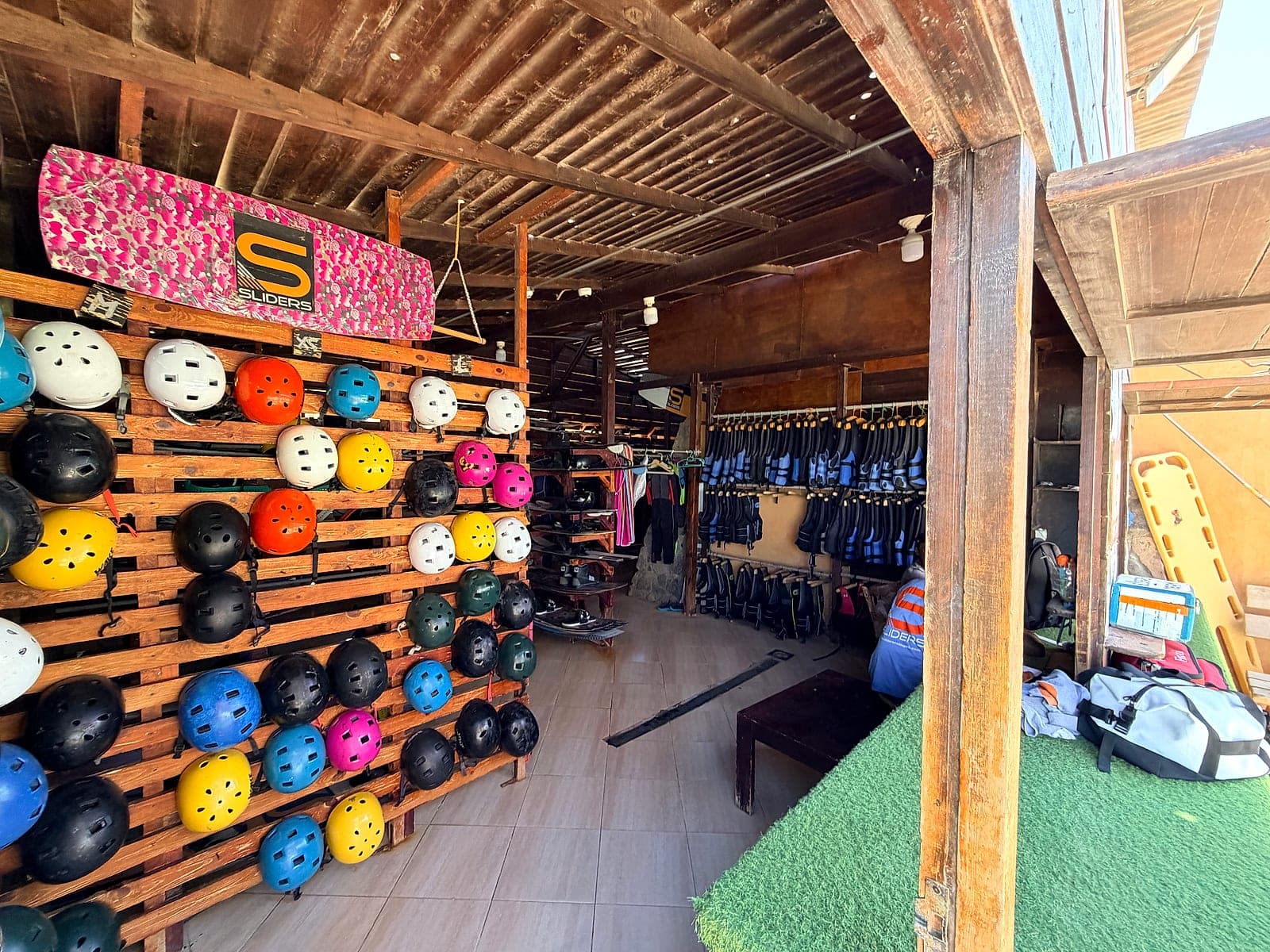Helmets, vests and boards racked in the gear shack at Sliders Cable Park